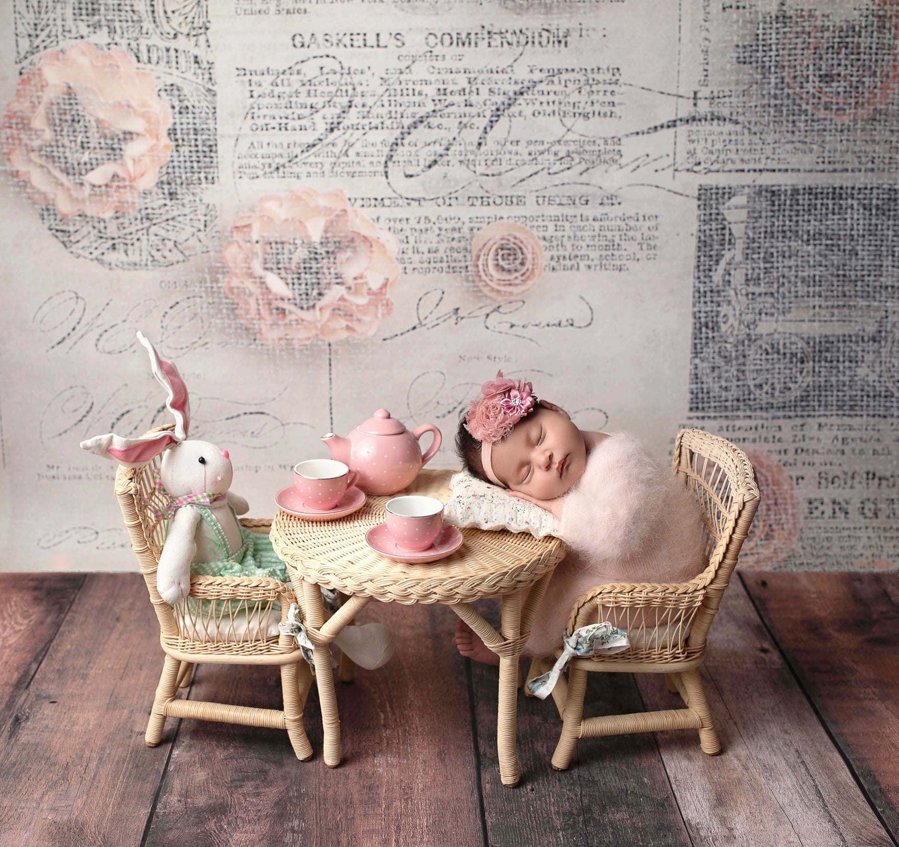 Sleeping newborn baby having a tea party with his bunny rabbit friend.