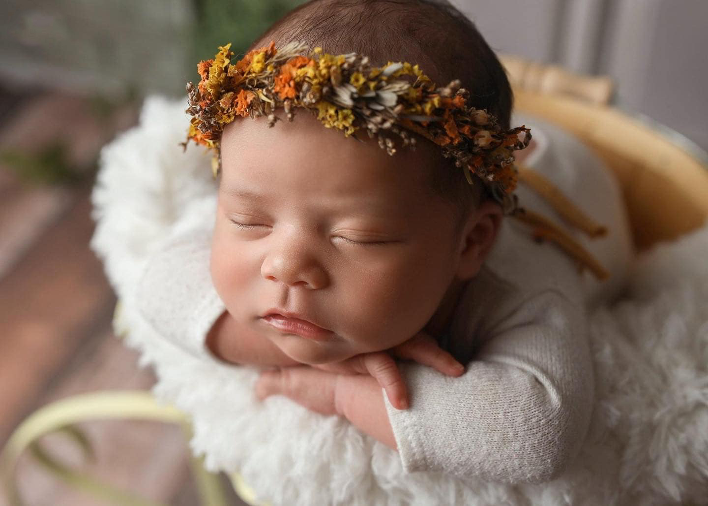 Sleepy newborn baby girl posing in floral headband visiting us after mom does prenatal yoga in Denver.