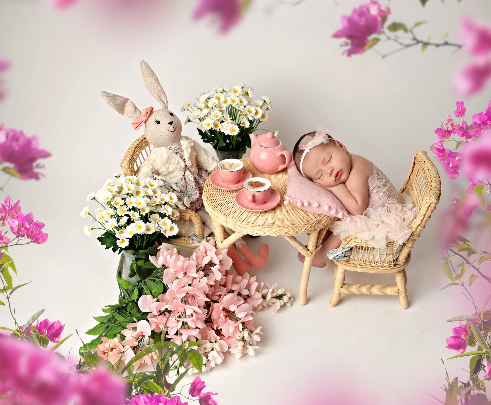 Newborn at her tea party surrounded by pretty floral set up.