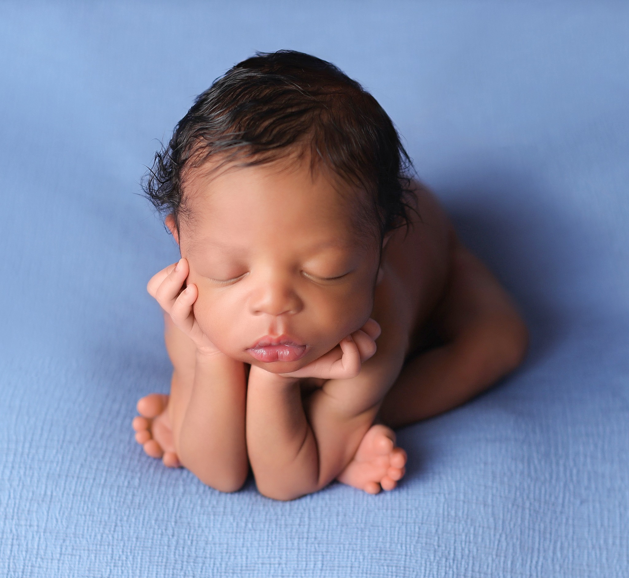 Cute little man posing on blue beanbag blanket at his newborn shoot after his aspen pediatrcians appointment.