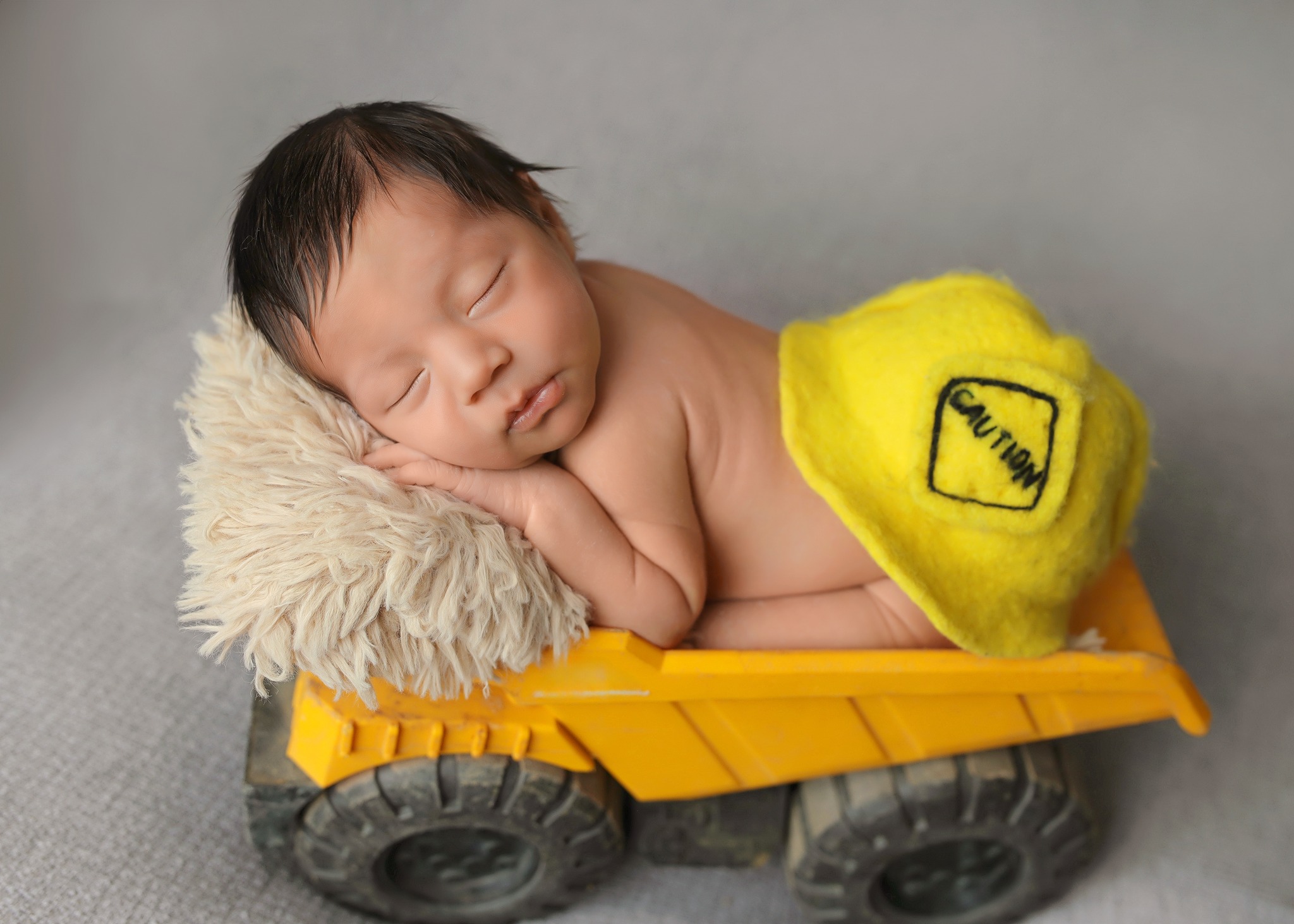 Cute construction working posing on his Tonka truck.