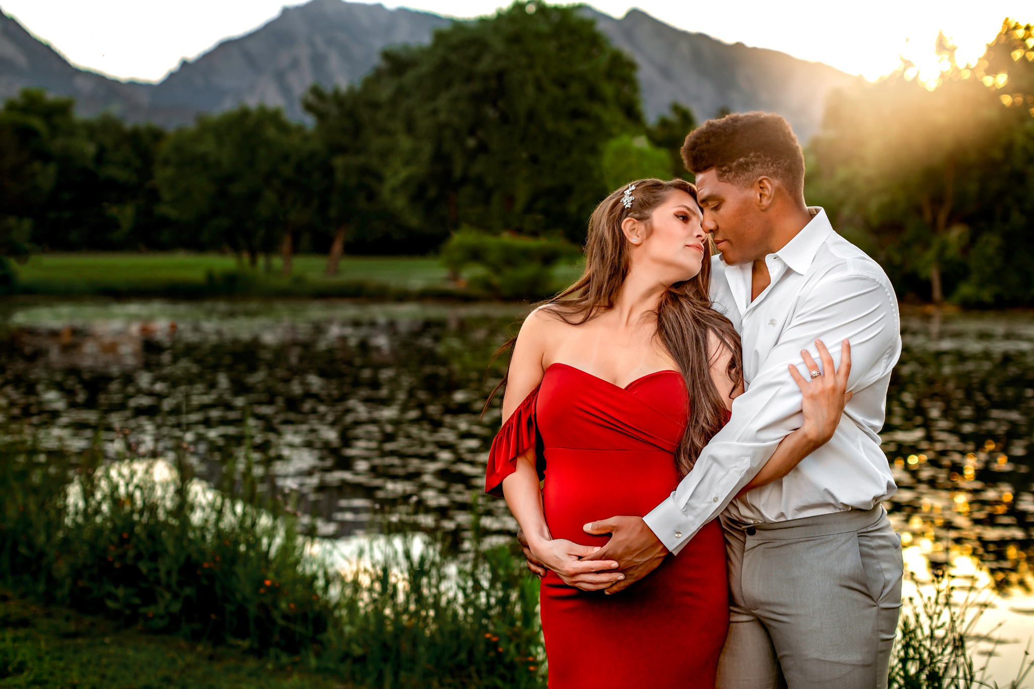 Beautiful maternity couple posing at Veale Lake in Boulder waiting to choose their Brighton midwife.