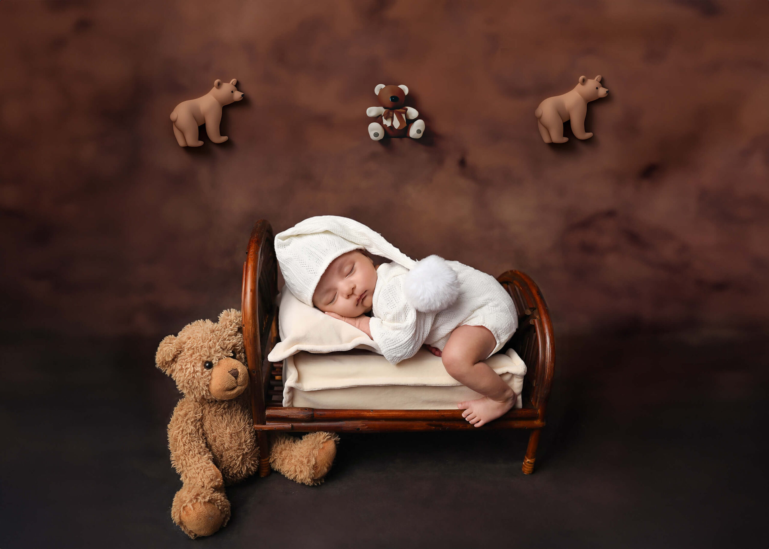 Cute newborn sleeping on vintage wooden bed at his denver newborn photography session.