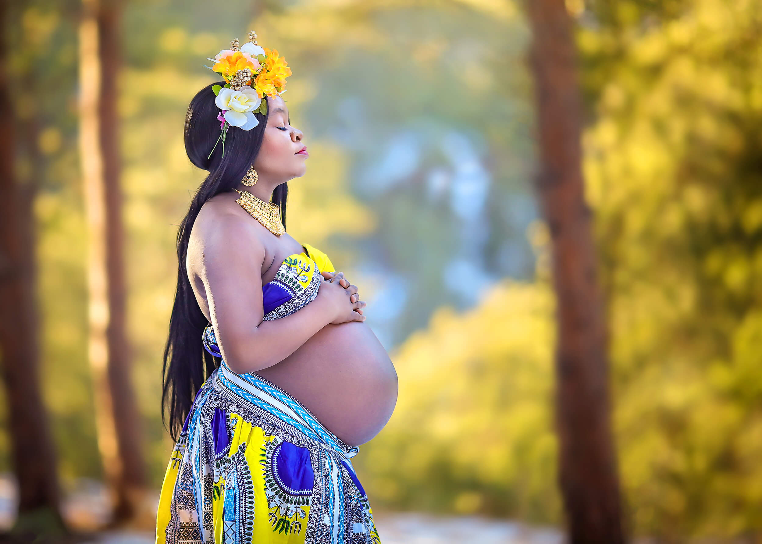 Beautiful pregnant momma posing in her authentic African attire after her Denver yoga studios session.