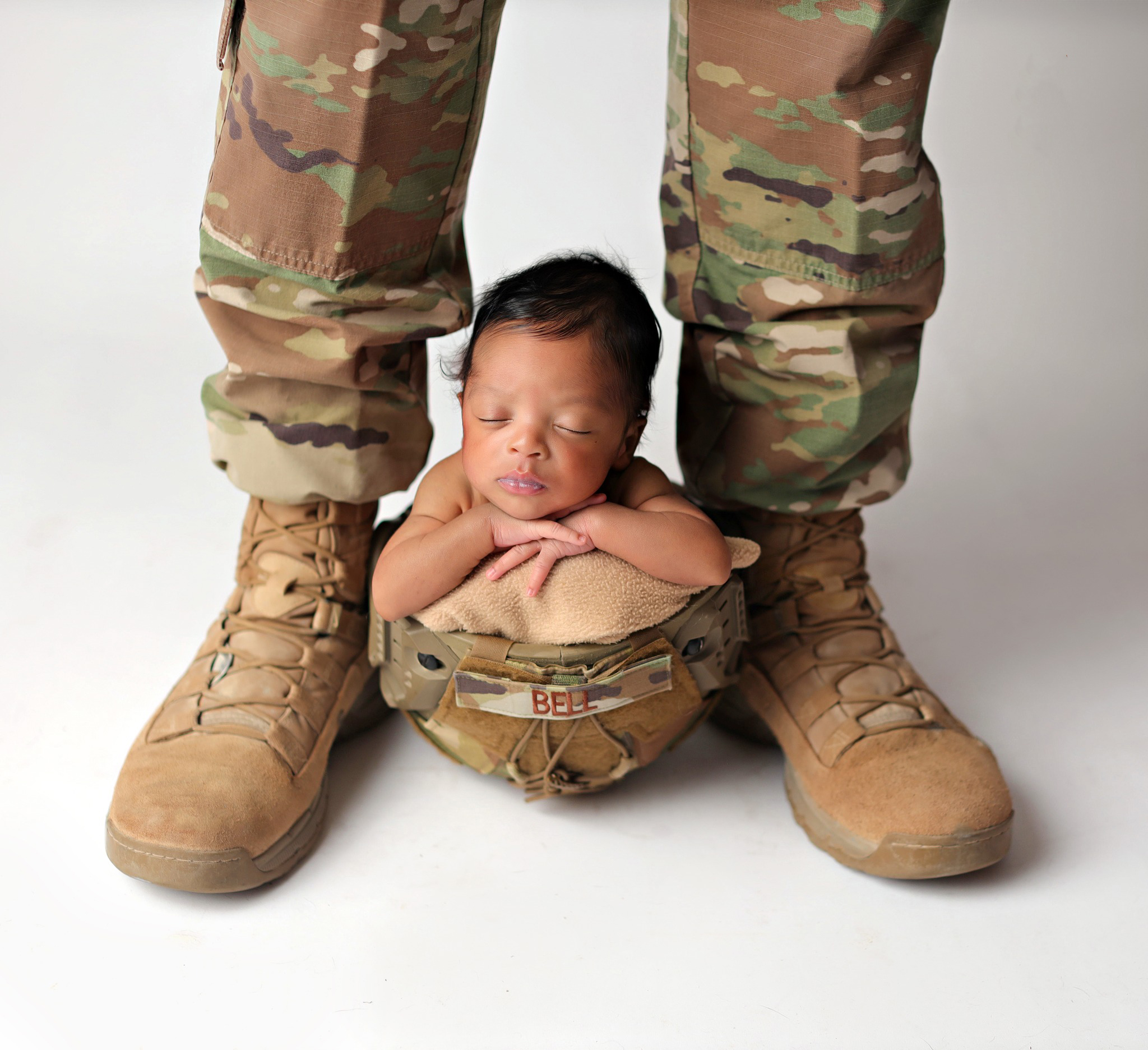 Newborn baby sleeping Dad's military gear after his Parker pediatricians appointment.